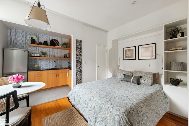 bedroom featuring freestanding refrigerator and light wood finished floors
