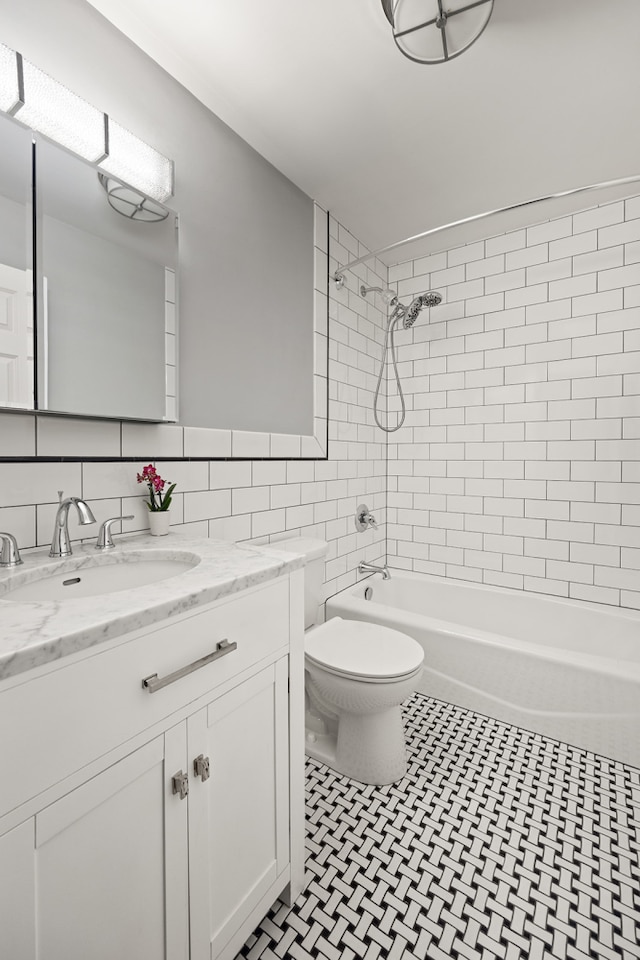 full bathroom with toilet, vanity, tile walls, and shower / bath combination