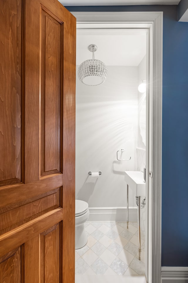 half bathroom featuring toilet and baseboards