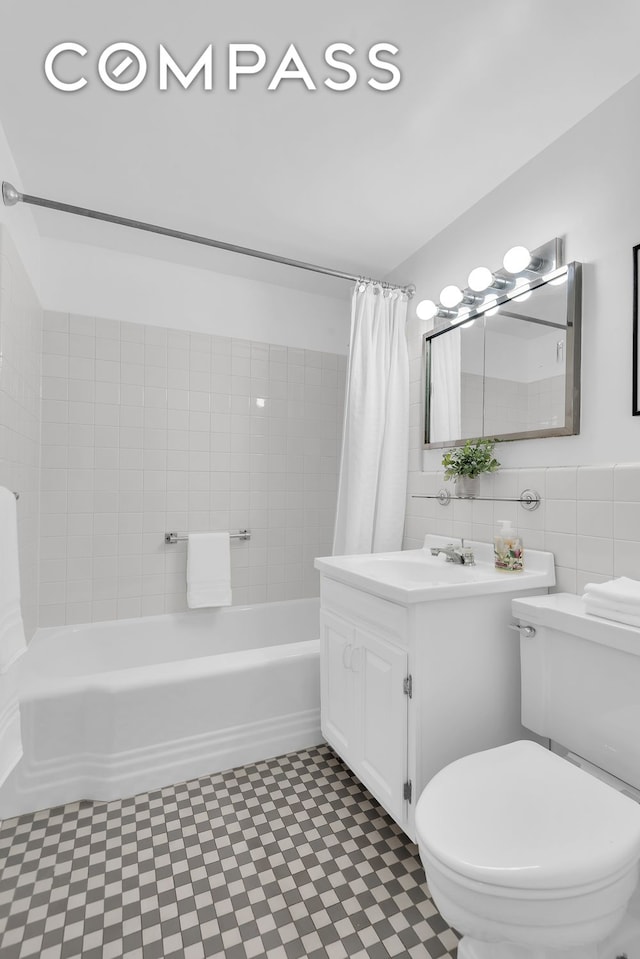 120 E 81st St Unit 8A, New York City, NY 10028 - bathroom with tile patterned floors, shower / bath combo with shower curtain, vanity, toilet, and tile walls