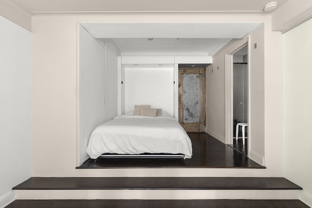 bedroom featuring baseboards and wood finished floors