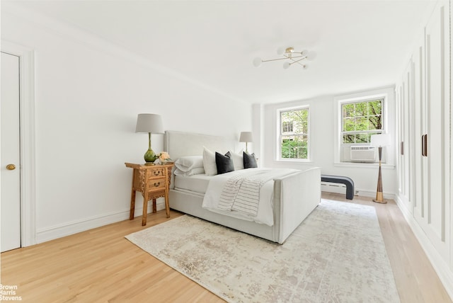 607 W End Ave Unit 4A, New York City, NY 10024 - bedroom featuring light wood-type flooring, cooling unit, a chandelier, and baseboards