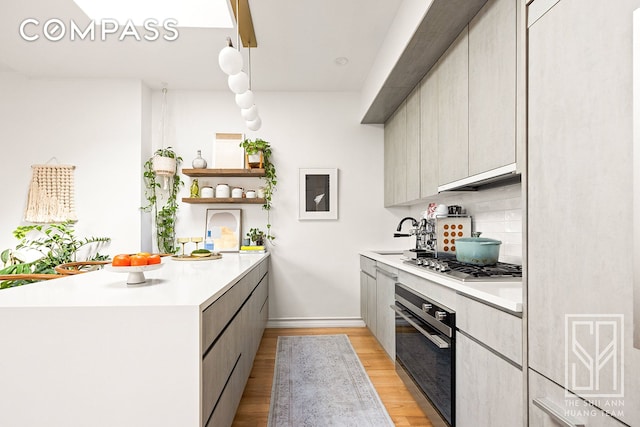 kitchen featuring oven, stainless steel gas cooktop, light countertops, and open shelves