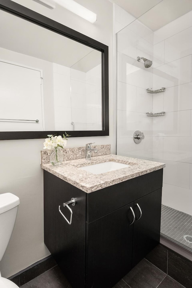 bathroom featuring vanity, a shower stall, and toilet