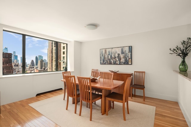 dining space with light wood finished floors and a view of skyline