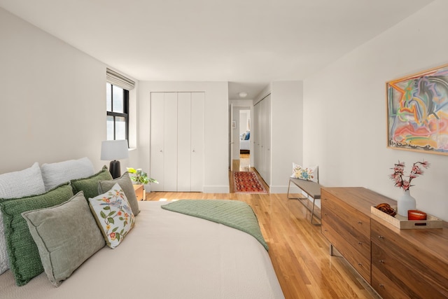 bedroom with light wood-type flooring and baseboards