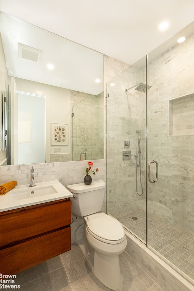 bathroom featuring toilet, a stall shower, vanity, tile walls, and recessed lighting