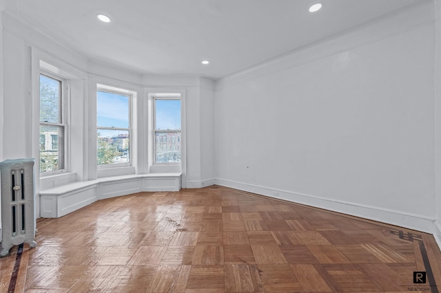 spare room featuring radiator and recessed lighting