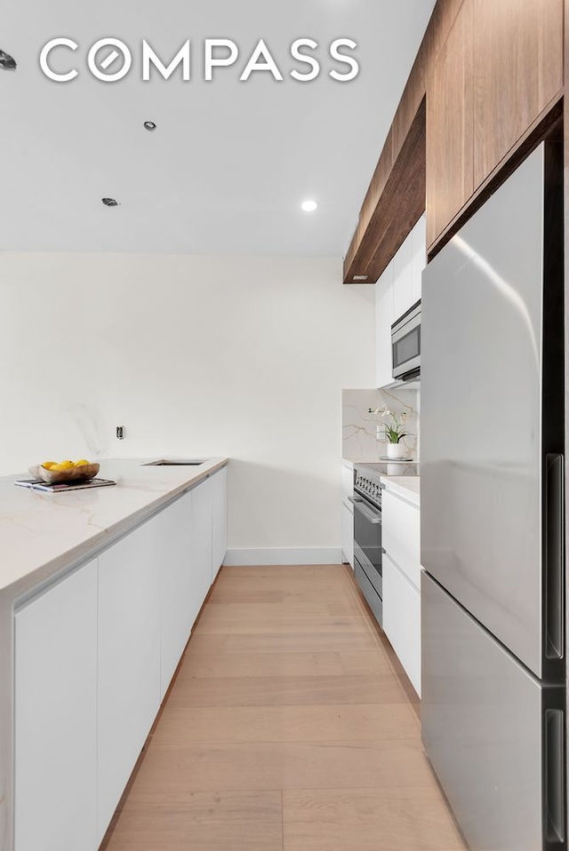 156 Somers St Unit 3B, New York City, NY 11233 - kitchen featuring stainless steel appliances, modern cabinets, white cabinets, baseboards, and tasteful backsplash