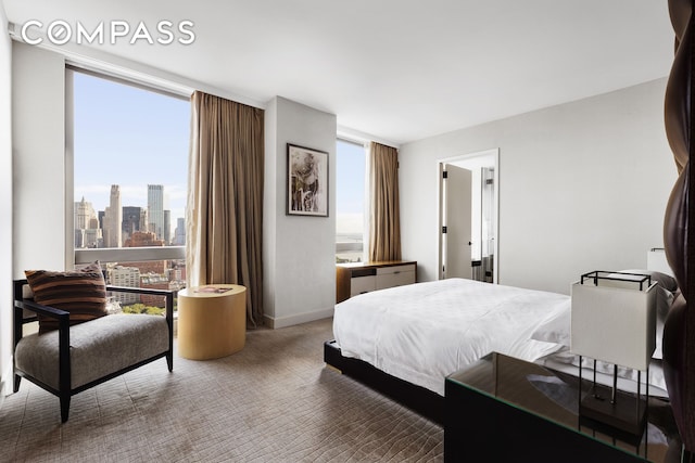 carpeted bedroom with baseboards and floor to ceiling windows