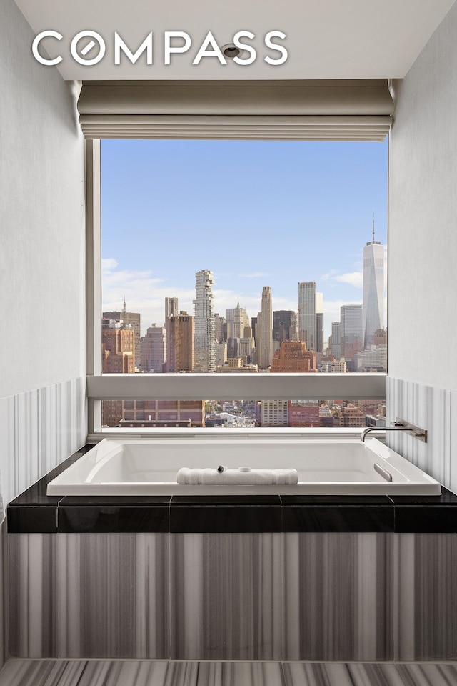full bathroom featuring a view of skyline and a bath