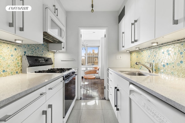 20 E 9th St Unit 18D, New York City, NY 10003 - kitchen with white appliances, a sink, decorative backsplash, white cabinets, and light stone countertops