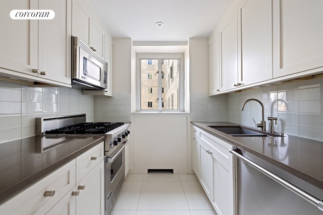 200 E 66th St Unit B1702, New York City, NY 10065 - kitchen with appliances with stainless steel finishes, a sink, dark countertops, and white cabinets
