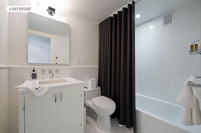 200 E 66th St Unit B1702, New York City, NY 10065 - bathroom with toilet, tile walls, vanity, a wainscoted wall, and shower / bath combination with curtain