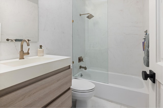 full bathroom with toilet, tub / shower combination, vanity, and tile walls