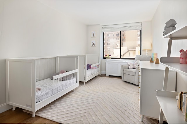 525 E 80th St Unit 9D, New York City, NY 10075 - bedroom featuring wood finished floors and a crib