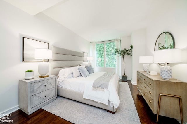 bedroom with dark wood-type flooring and baseboards