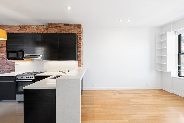 64 Macdougal St Unit 15, New York City, NY 10012 - kitchen with dark cabinets, range hood, stainless steel range with gas cooktop, black microwave, and recessed lighting