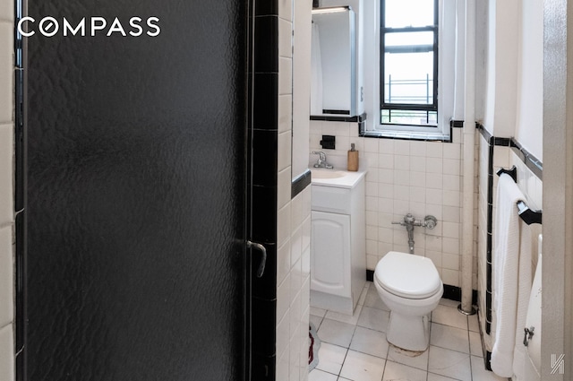 35-06 88th St Unit 5E, New York City, NY 11372 - bathroom featuring tile walls, tile patterned floors, vanity, a wainscoted wall, and a shower with door