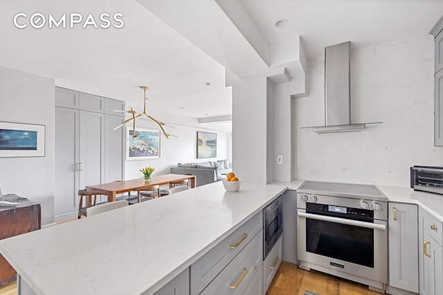 80 E End Ave Unit 17C, New York City, NY 10028 - kitchen with appliances with stainless steel finishes, gray cabinetry, wall chimney exhaust hood, light wood-style flooring, and light stone counters