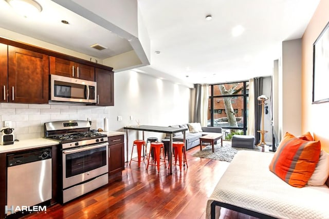 2022 Madison Ave, New York City, NY 10035 - kitchen featuring stainless steel appliances, plenty of natural light, light countertops, dark wood-type flooring, and expansive windows