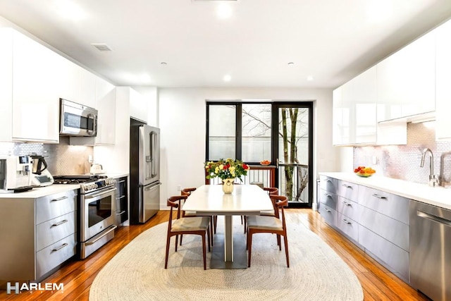 2022 Madison Ave, New York City, NY 10035 - kitchen with appliances with stainless steel finishes, modern cabinets, decorative backsplash, a sink, and recessed lighting