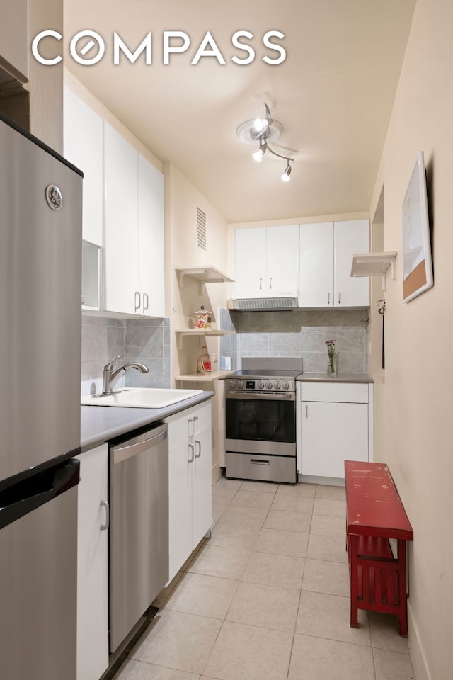 510 E 84th St Unit 1B, New York City, NY 10028 - kitchen featuring stainless steel appliances, tasteful backsplash, extractor fan, a sink, and white cabinetry