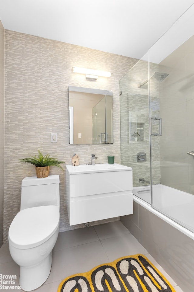 501 E 79th St Unit 5A, New York City, NY 10075 - full bath with bath / shower combo with glass door, tile patterned flooring, vanity, tile walls, and toilet