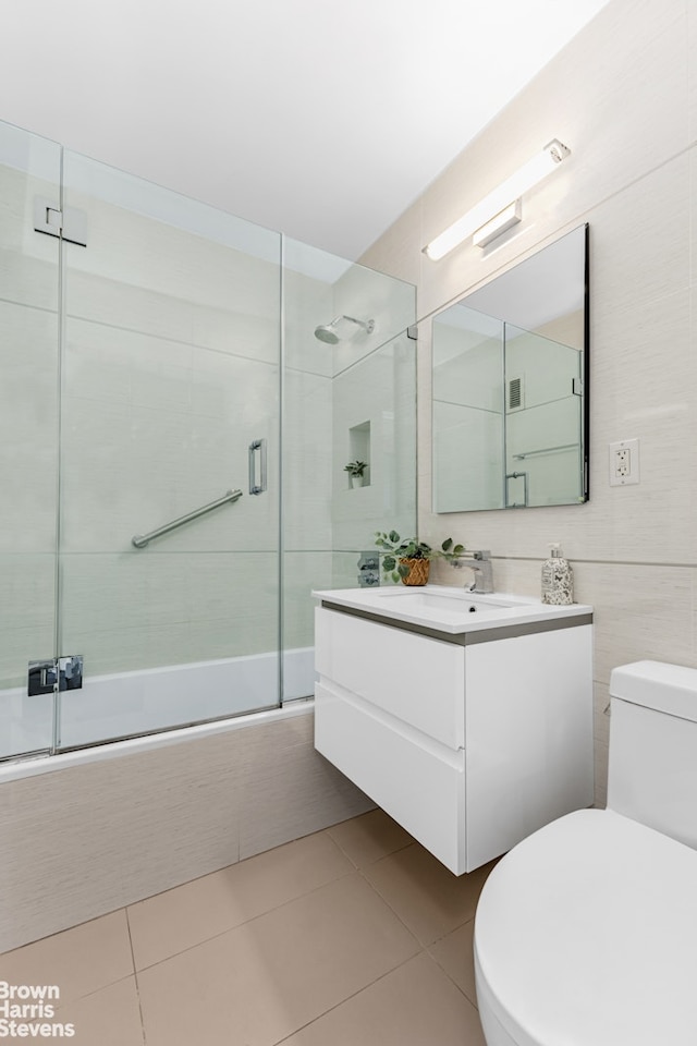 501 E 79th St Unit 5A, New York City, NY 10075 - bathroom featuring toilet, vanity, combined bath / shower with glass door, and tile patterned floors