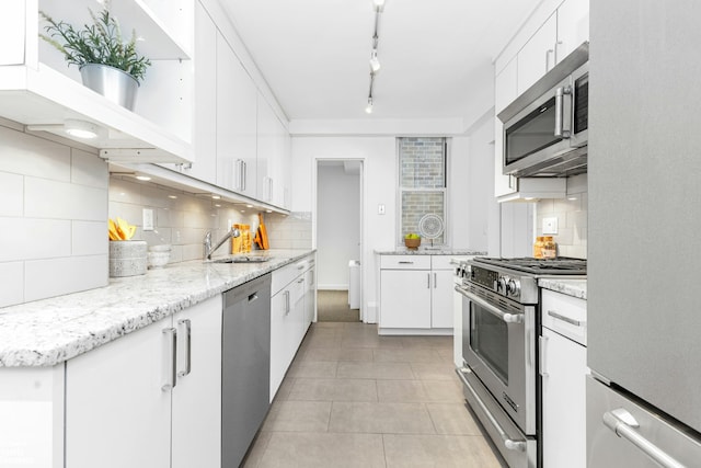 501 E 79th St Unit 5A, New York City, NY 10075 - kitchen with appliances with stainless steel finishes, tasteful backsplash, and white cabinetry