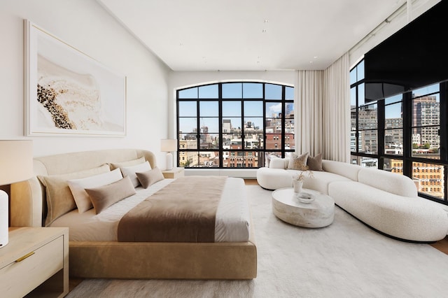 bedroom with multiple windows and wood finished floors
