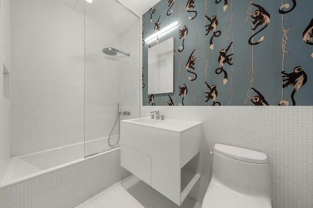 full bathroom with toilet, vanity, tile walls, and tiled shower / bath