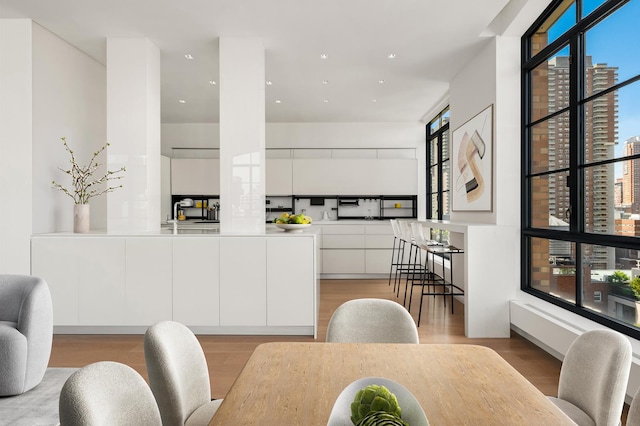 dining space with light wood-style flooring, a city view, and recessed lighting