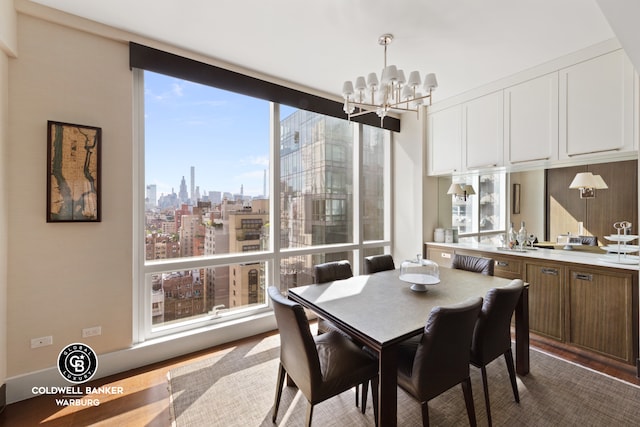 151 E 85th St Unit 17J, New York City, NY 10028 - dining room featuring a chandelier, a view of skyline, and dark wood-style flooring