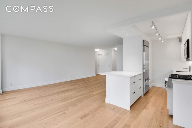 170 W End Ave Unit 12B, New York City, NY 10023 - kitchen with white cabinets, baseboards, light wood-style floors, light countertops, and appliances with stainless steel finishes