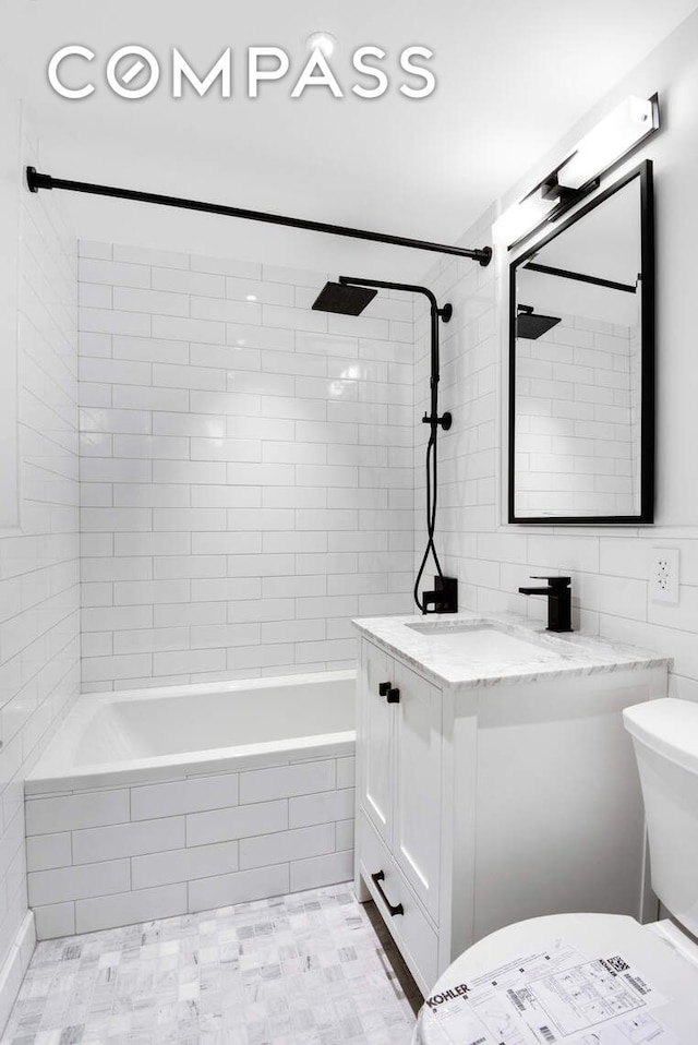 170 W End Ave Unit 12B, New York City, NY 10023 - full bathroom featuring toilet, vanity, tiled shower / bath, tile walls, and tile patterned floors