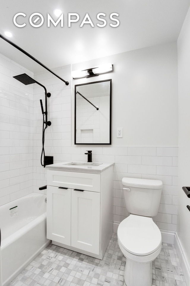 205 W End Ave Unit 15H, New York City, NY 10023 - bathroom featuring vanity, tile walls, toilet, washtub / shower combination, and a wainscoted wall