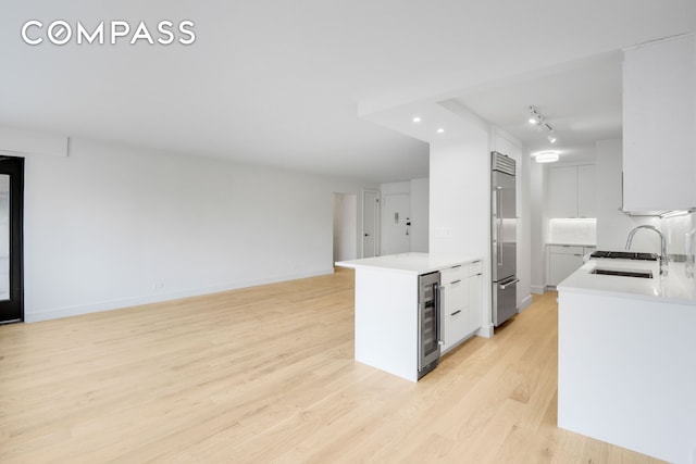 205 W End Ave Unit 15H, New York City, NY 10023 - kitchen with high quality fridge, wine cooler, a sink, light wood-style floors, and light countertops