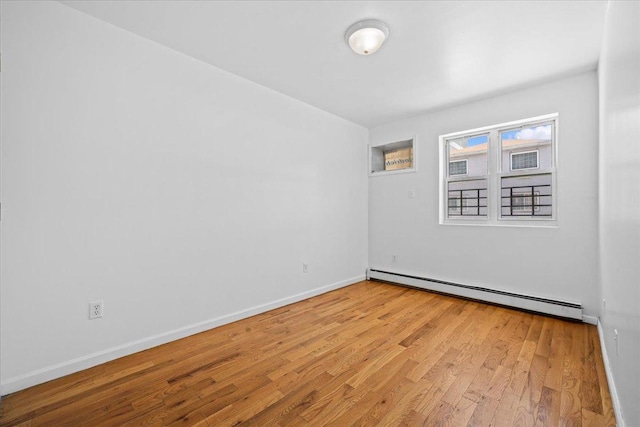 53 Woods Place, New York City, NY 11226 - unfurnished room featuring a baseboard heating unit, wood finished floors, and baseboards