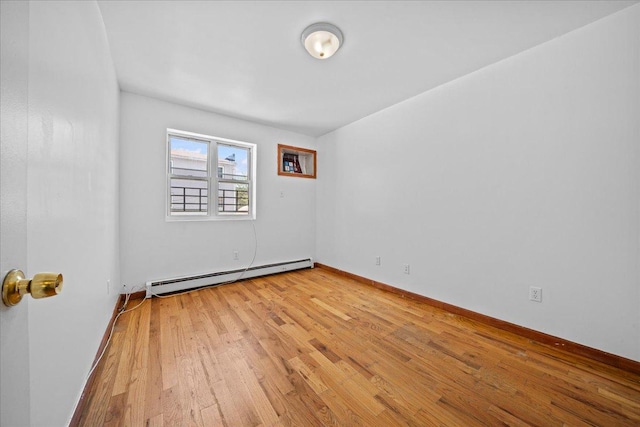 53 Woods Place, New York City, NY 11226 - spare room featuring baseboard heating, light wood-style flooring, and baseboards