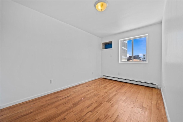 53 Woods Place, New York City, NY 11226 - spare room featuring a baseboard radiator, light wood-type flooring, and baseboards