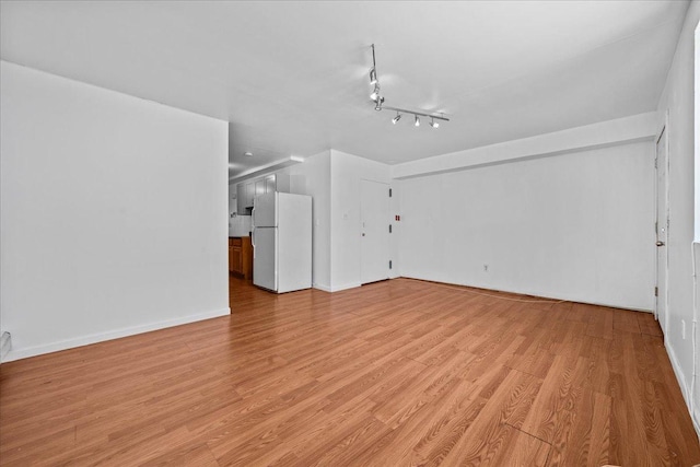53 Woods Place, New York City, NY 11226 - unfurnished living room with light wood finished floors and baseboards