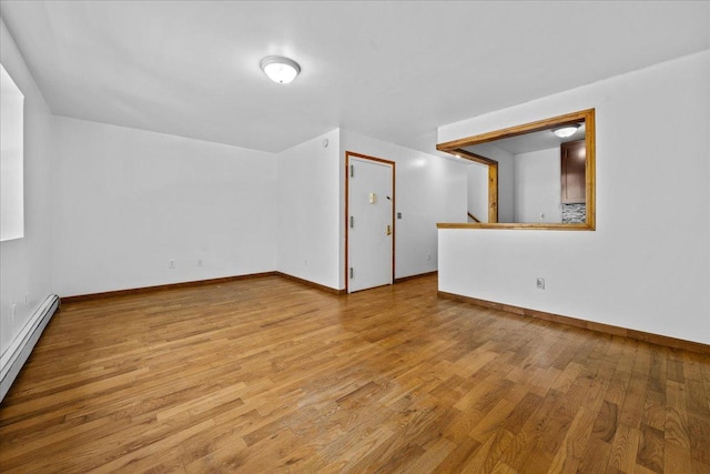 53 Woods Place, New York City, NY 11226 - additional living space with a baseboard heating unit, wood finished floors, and baseboards