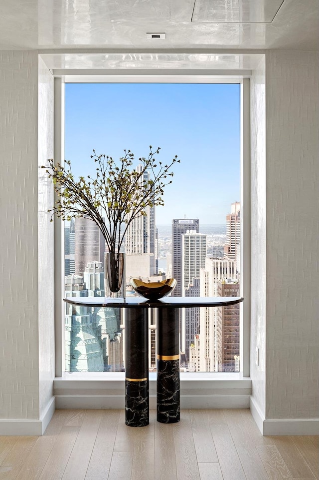 detailed view of wood finished floors, a city view, and baseboards