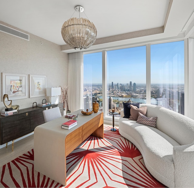 living area with a view of city, a chandelier, and wood finished floors