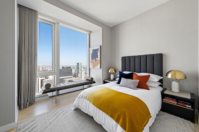 bedroom featuring wood finished floors and a view of city
