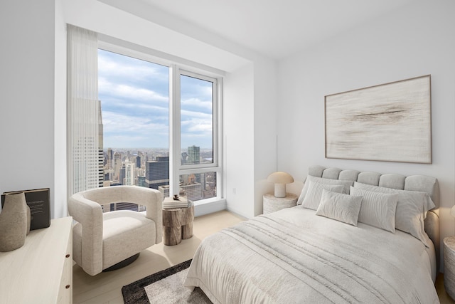 138 E 50th St Unit 68, New York City, NY 10022 - bedroom featuring wood finished floors, multiple windows, and a city view