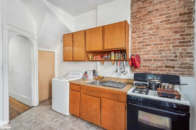 7 Sylvan Ct, New York City, NY 10035 - kitchen with range with gas stovetop, washer / dryer, a sink, light countertops, and brown cabinetry