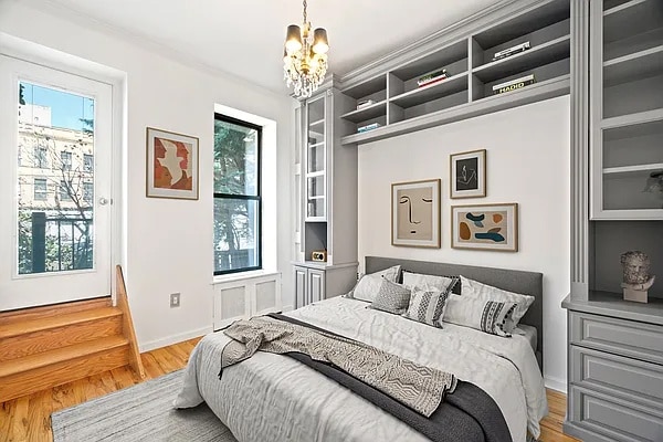 bedroom with a chandelier, multiple windows, and wood finished floors