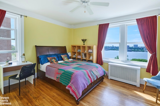 360 Riverside Dr Unit 8A, New York City, NY 10025 - bedroom with radiator, multiple windows, wood finished floors, and a water view